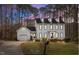 Two-story home with a black roof, dormer windows, and an attached garage with a beautiful lawn at 7904 Kingsland Dr, Raleigh, NC 27613