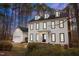 A charming white two-story home with black trim and a side-entry garage, surrounded by mature trees at 7904 Kingsland Dr, Raleigh, NC 27613