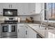 Bright kitchen featuring an island with granite countertops, stainless steel appliances, and hardwood flooring at 7904 Kingsland Dr, Raleigh, NC 27613