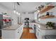 Bright kitchen featuring an island with granite countertops, stainless steel appliances, and hardwood flooring at 7904 Kingsland Dr, Raleigh, NC 27613