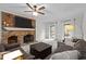 Bright living room with a cozy brick fireplace, neutral carpeting and a ceiling fan at 7904 Kingsland Dr, Raleigh, NC 27613