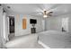 Spacious main bedroom with neutral tones features a ceiling fan, TV, and access to an ensuite bathroom and walk-in closet at 7904 Kingsland Dr, Raleigh, NC 27613