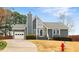 Charming gray home with stone accents, manicured lawn, and attached garage at 809 Handel Ln, Apex, NC 27502