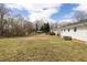 Large, grassy backyard surrounded by trees and fencing, ideal for outdoor activities at 825 Parkwood St, Burlington, NC 27215