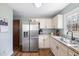 Well-lit kitchen features granite counters, stainless fridge and an undermounted sink with window view at 825 Parkwood St, Burlington, NC 27215