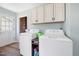 Bright laundry room features washer, dryer, cabinets, storage, and access to the exterior at 825 Parkwood St, Burlington, NC 27215