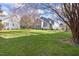 Lush backyard with mature trees and townhome exteriors on a sunny day at 8310 Hempshire Pl # 106, Raleigh, NC 27613