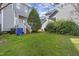 Grassy backyard with trees, deck, and townhome exterior at 8310 Hempshire Pl # 106, Raleigh, NC 27613