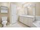 Bright bathroom with single sink vanity and large mirror, toilet, and storage cabinet at 8310 Hempshire Pl # 106, Raleigh, NC 27613