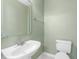 Clean half-bath with pedestal sink and toilet featuring neutral paint at 8310 Hempshire Pl # 106, Raleigh, NC 27613