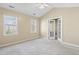 Bright bedroom with two windows and glass panel doors leading to another space at 8310 Hempshire Pl # 106, Raleigh, NC 27613