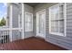 Cozy deck with wood flooring, gray siding, white trim, and natural light at 8310 Hempshire Pl # 106, Raleigh, NC 27613