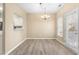 Bright dining area with modern lighting, hardwood floors, and convenient access to outdoor patio at 8310 Hempshire Pl # 106, Raleigh, NC 27613
