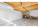 Unfinished garage with exposed ceiling joists, storage loft, and utility connections at 8310 Hempshire Pl # 106, Raleigh, NC 27613