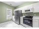 Updated kitchen featuring white cabinets, stainless steel appliances, and stylish marble floors at 8310 Hempshire Pl # 106, Raleigh, NC 27613