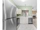 Open kitchen with stainless steel appliances and a view into a cozy living room with a fireplace at 8310 Hempshire Pl # 106, Raleigh, NC 27613