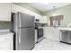 Well-lit kitchen with stainless steel appliances, white cabinets, and marble-patterned floors at 8310 Hempshire Pl # 106, Raleigh, NC 27613