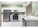 Bright kitchen with stainless steel appliances, white cabinetry, and ample counter space at 8310 Hempshire Pl # 106, Raleigh, NC 27613