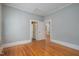A quaint bedroom with hardwood floors, light blue walls, and two doorways leading to other rooms at 907 Holloway St, Durham, NC 27701