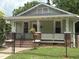 Charming single-story home featuring a cozy front porch with decorative columns and a well-maintained yard at 907 Holloway St, Durham, NC 27701
