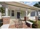 Inviting covered front porch with brick pillars, decorative columns, and white railings at 907 Holloway St, Durham, NC 27701