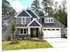 Charming two-story home with a manicured lawn, stone accents, and a spacious two-car garage at 9160 Dupree Meadow Dr # 13, Angier, NC 27501