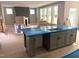View of the kitchen island into the living room with a fireplace and large picture windows at 9160 Dupree Meadow Dr # 13, Angier, NC 27501