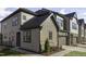 Attractive townhome featuring a stone facade, a gray garage door, and manicured lawns at 960 Double Helix Rd, Apex, NC 27523