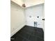 Well-organized laundry room with dark tile flooring, white trim and shelving, plus convenient hookups at 960 Double Helix Rd, Apex, NC 27523