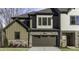 Modern townhome exterior with stone accents, two-car garage, and well-manicured lawn, offering a stylish curb appeal at 970 Double Helix Rd, Apex, NC 27523
