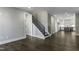 Staircase with hardwood stairs and iron railing near kitchen and entryways at 970 Double Helix Rd, Apex, NC 27523