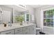 Bright bathroom featuring double sinks, a large mirror, and a window for natural light at 98 Beach Ln, Henderson, NC 27537