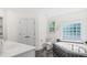 Bathroom featuring a tub, toilet, vanity, black tile, and a window at 98 Beach Ln, Henderson, NC 27537