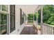 Covered front porch of a well-maintained home, featuring a wooden floor and classic black shutters at 98 Beach Ln, Henderson, NC 27537