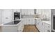 Well-appointed kitchen with stainless steel appliances, white cabinets, and hardwood floors at 98 Beach Ln, Henderson, NC 27537