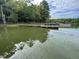 Beautiful lake view with docks and boats in the water under a partly cloudy sky with trees in the background at 98 Beach Ln, Henderson, NC 27537