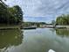 A view of the lake surrounded by trees and docks under a partly cloudy sky at 98 Beach Ln, Henderson, NC 27537