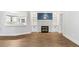 Living room featuring hardwood floors, a fireplace, built-in shelving, and an opening to the kitchen at 98 Beach Ln, Henderson, NC 27537