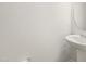 A pedestal sink and round mirror are featured in the neutral-toned powder room at 10 Forest Brook Way, Clayton, NC 27520