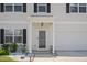 Home's front door with white rock landscaping, charming lion statue, and an attached garage at 10 Forest Brook Way, Clayton, NC 27520