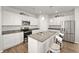 Bright kitchen features white cabinets, stainless steel appliances, granite counters and a large island at 10 Forest Brook Way, Clayton, NC 27520