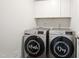 Modern laundry room with front-load washer and dryer and overhead cabinets at 10 Forest Brook Way, Clayton, NC 27520