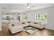 Open concept living area with large sectional, wood flooring, and seamless flow to the kitchen at 10 Forest Brook Way, Clayton, NC 27520