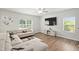 Inviting living room with large sectional couch, ceiling fan, and hardwood floors at 10 Forest Brook Way, Clayton, NC 27520