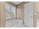 Bright bathroom displaying soaking tub under a window for natural light at 1007 Olde Midway Ct, Knightdale, NC 27545