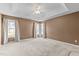 Spacious bedroom featuring tray ceilings, neutral walls, and natural light from multiple windows at 1007 Olde Midway Ct, Knightdale, NC 27545