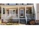 Inviting front porch with classic white columns, hanging flower baskets, and comfortable seating at 1007 Olde Midway Ct, Knightdale, NC 27545