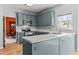 Bright kitchen featuring blue cabinetry, stainless steel appliances, and light countertops at 1007 Olde Midway Ct, Knightdale, NC 27545