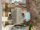 Overhead view showcasing a kidney-shaped pool with patios and outdoor spaces in a private backyard setting at 1009 Bexley Hills Bnd, Apex, NC 27502