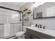 Renovated bathroom featuring a glass-enclosed shower, modern vanity, and decorative shelves at 1033 Forest Glen Dr, Raleigh, NC 27603